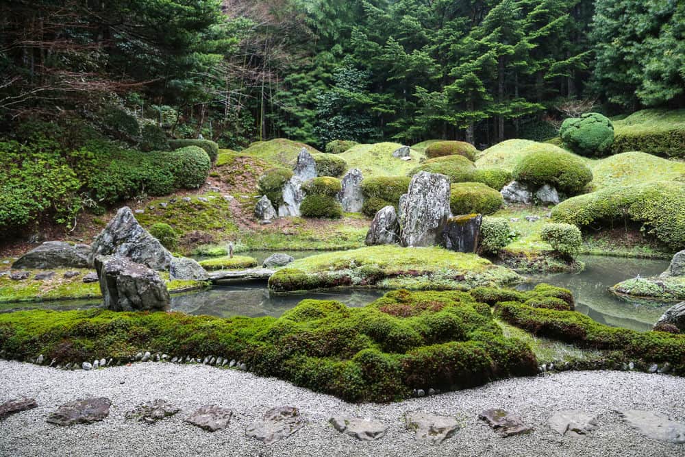 宁静的日本禅宗花园，有池塘、岩石、砾石和苔藓