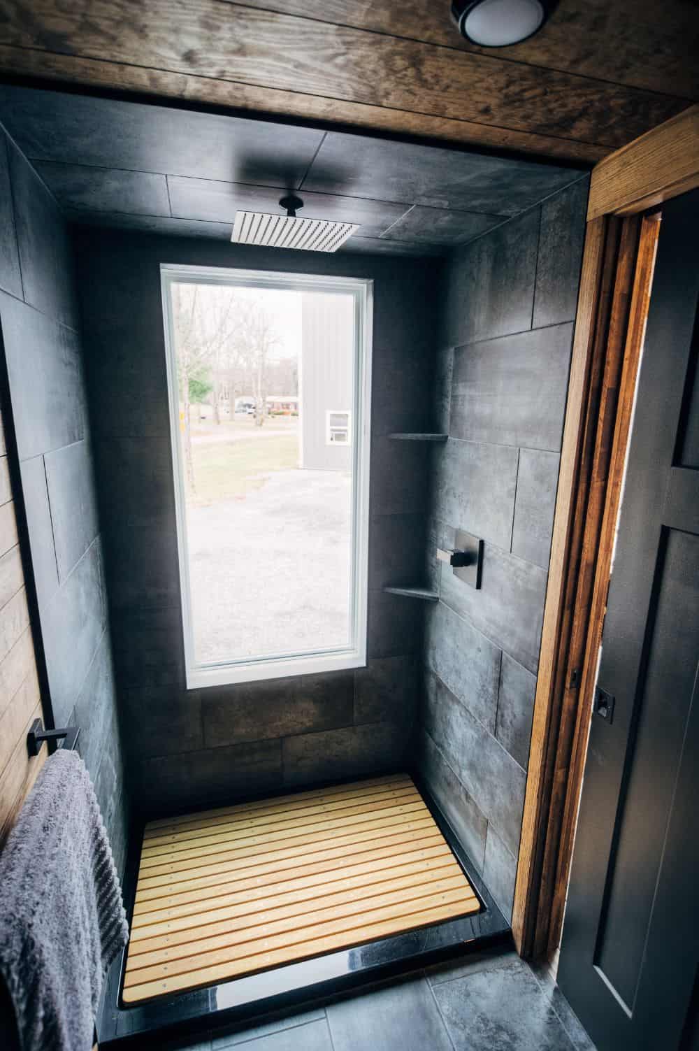 步入式淋浴间，大窗户，木地板，深灰色瓷砖。这个特别的淋浴享受雨水淋浴头。