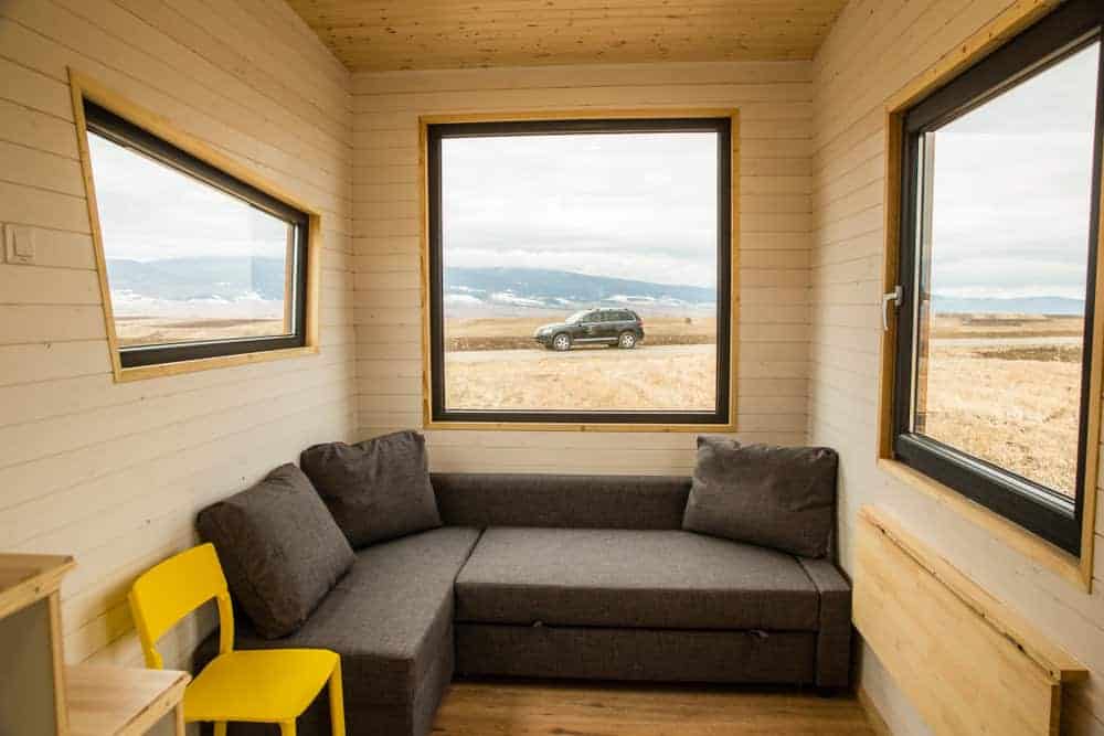 小房子里的l型组合长凳沙发，大窗户带来充足的光线。