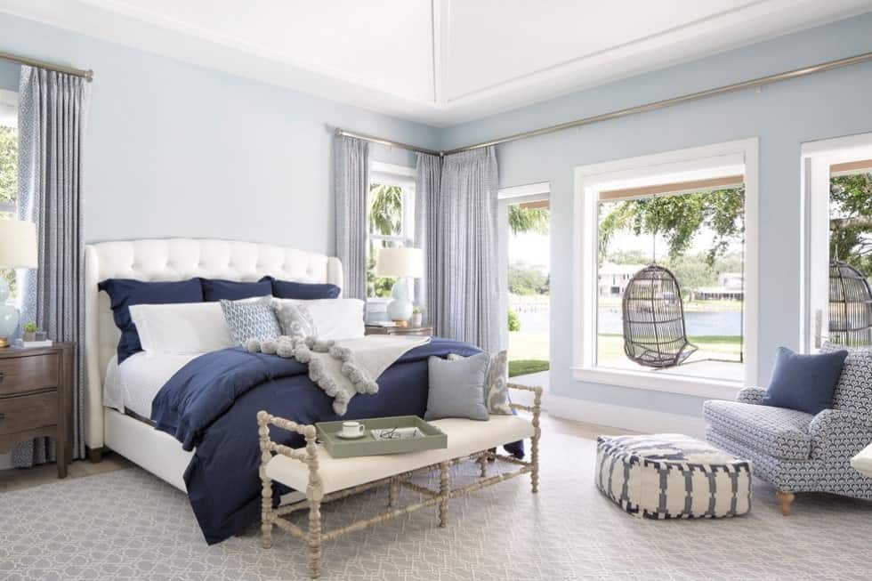 这间主卧室设有豪华的白色床和优雅的地毯，以及可爱的窗帘。这个房间还有一个通往后院的门口。