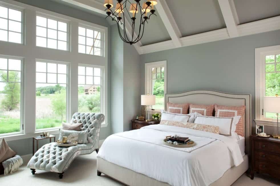 一个优雅的主卧室，有蓝灰色的墙壁和天花板，带横梁和地毯地板。