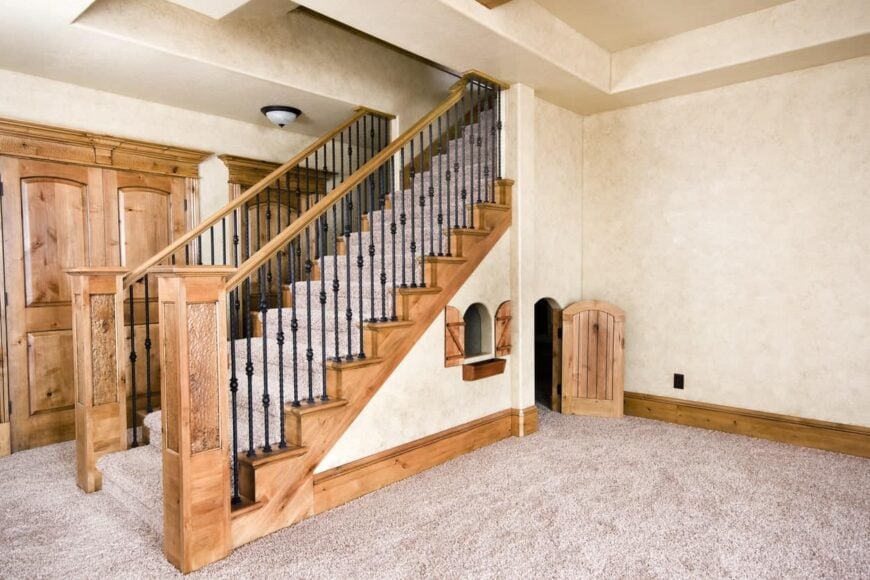 一个非常吸引人的储存楼梯，地毯地板和黑色铁栏杆的木制扶手。