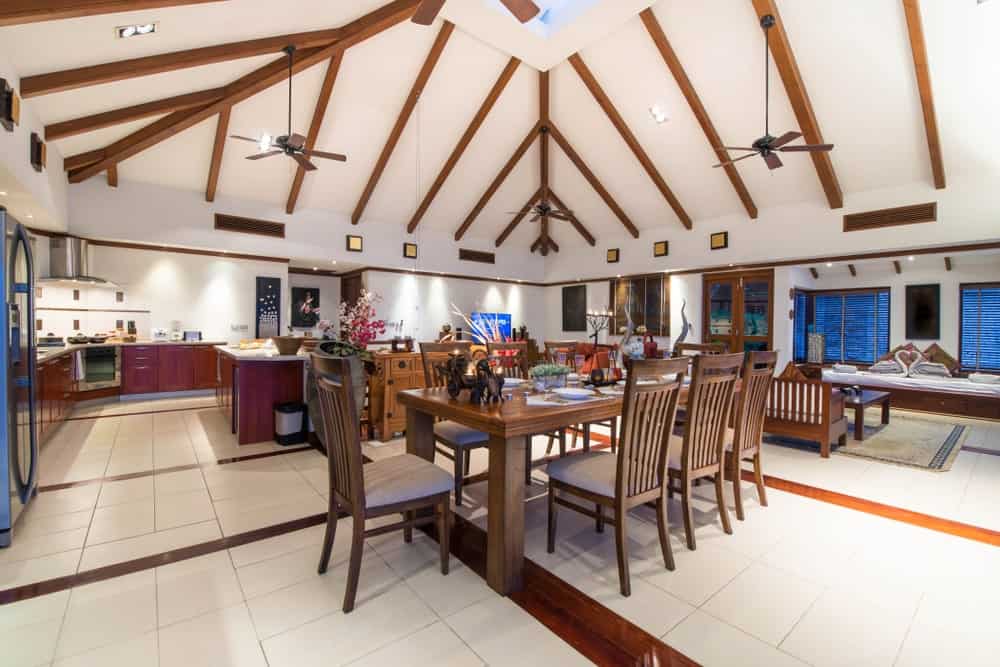 宽敞的房间，设有乡村餐桌，位于家庭时尚的地板上，在高高的天花板下。