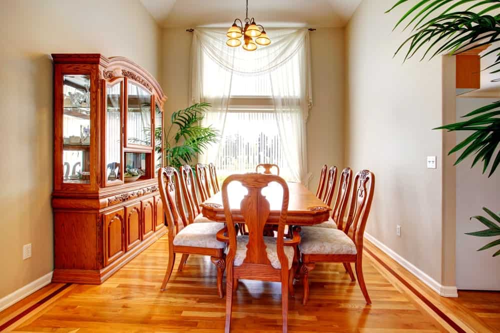 这所房子拥有一套优雅的餐桌和椅子设置在家里的硬木地板上。