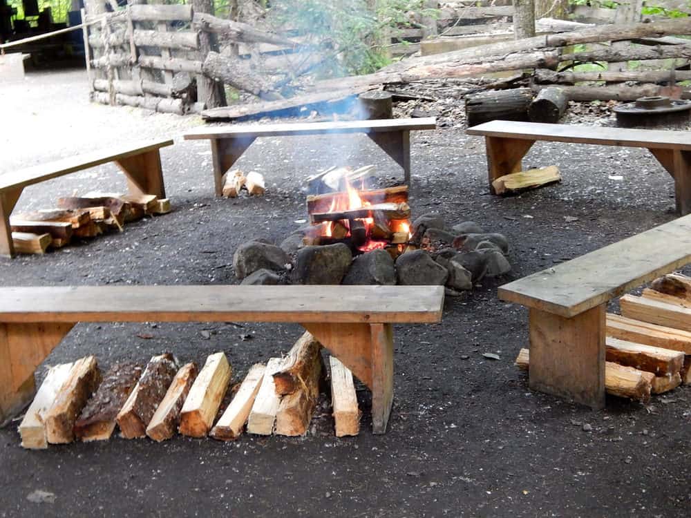 简单的DIY木板凳周围的岩石火坑。这是DIY火坑座椅最简单的方法。