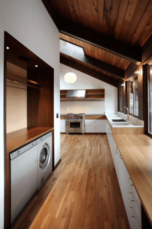 这间厨房拥有与裸露横梁的木棚天花板相匹配的硬木地板。