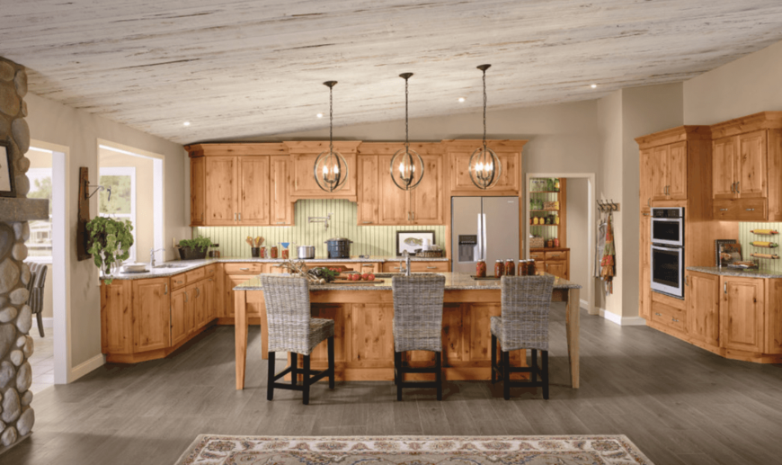 大型厨房设有早餐吧，由悬挂在棚顶上的吊灯照明。灰色硬木地板为该区域增添了风格。