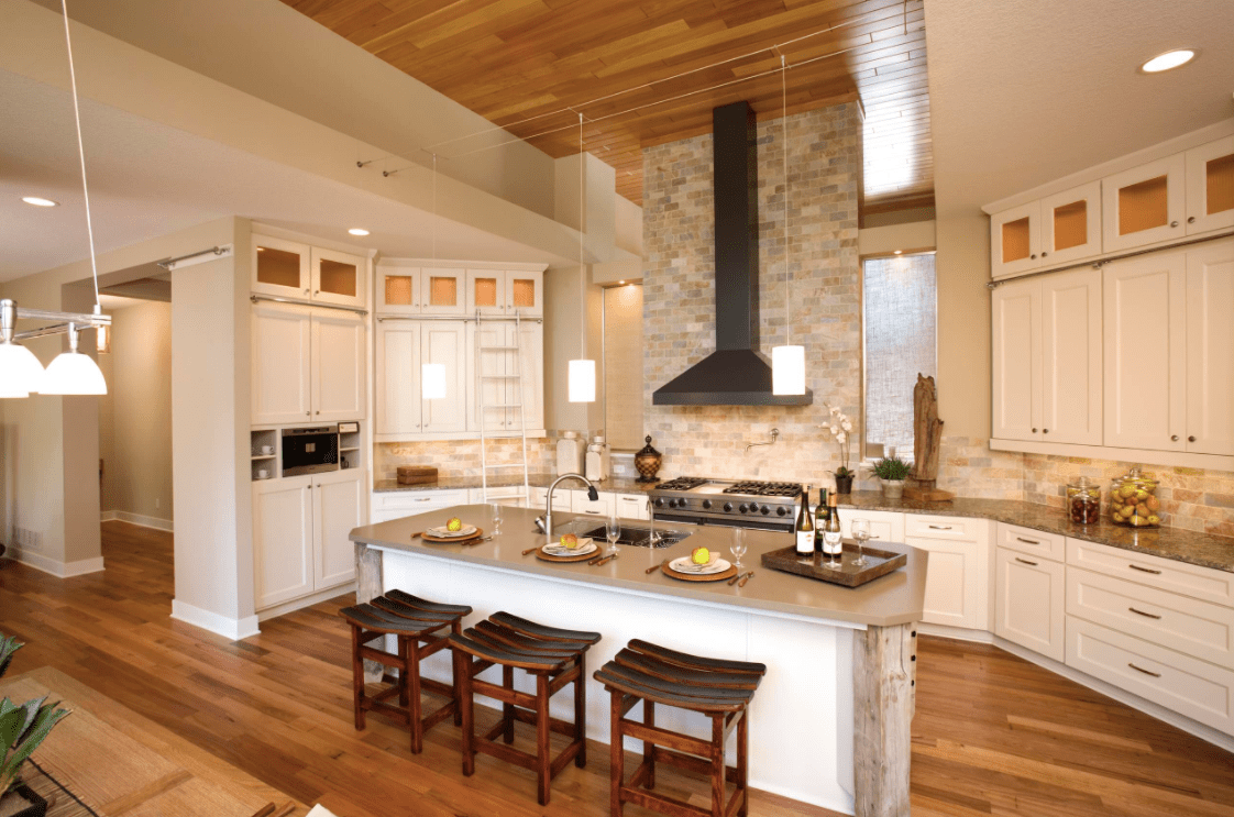 这间厨房拥有一个设置在家里硬木地板上的早餐吧台。砖墙的后挡板为房间增添了优雅。