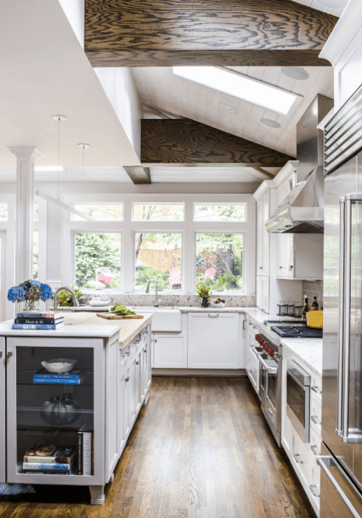 白色厨房设有硬木地板和棚顶。