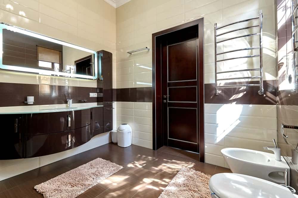 主浴室有一个令人惊叹的浮动洗手池和硬木地板，瓷砖墙和高高的天花板。
