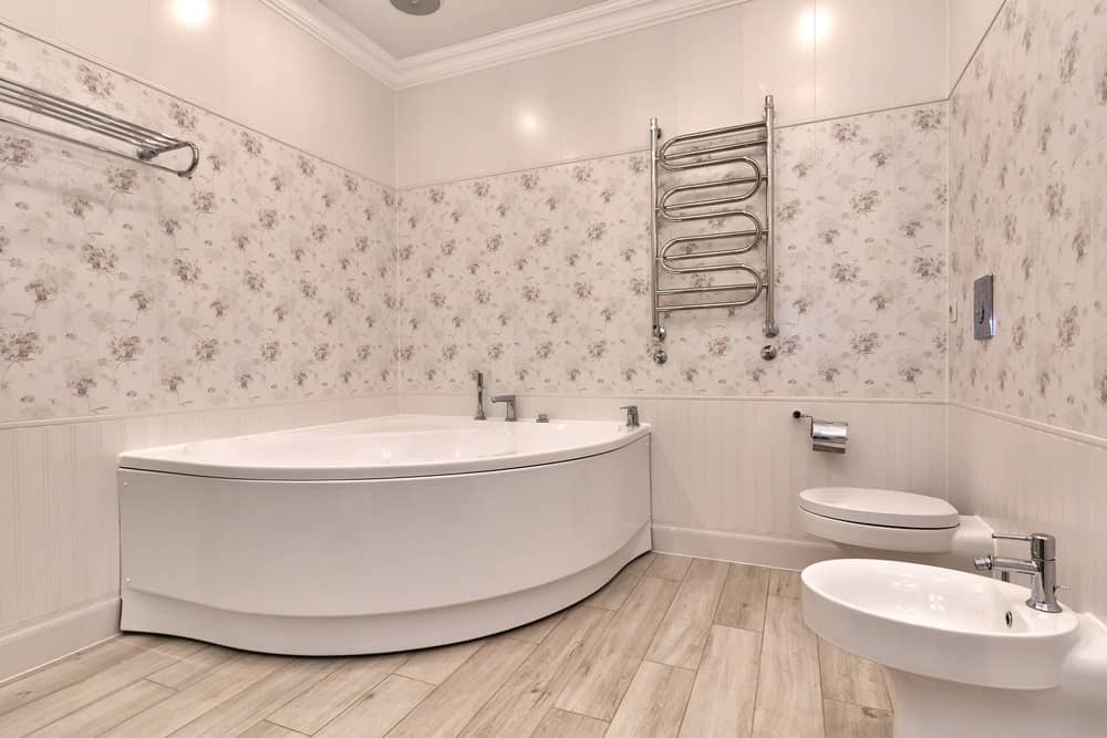 主浴缸拥有优雅的墙壁和一个大的角落浴缸设置在硬木地板上。