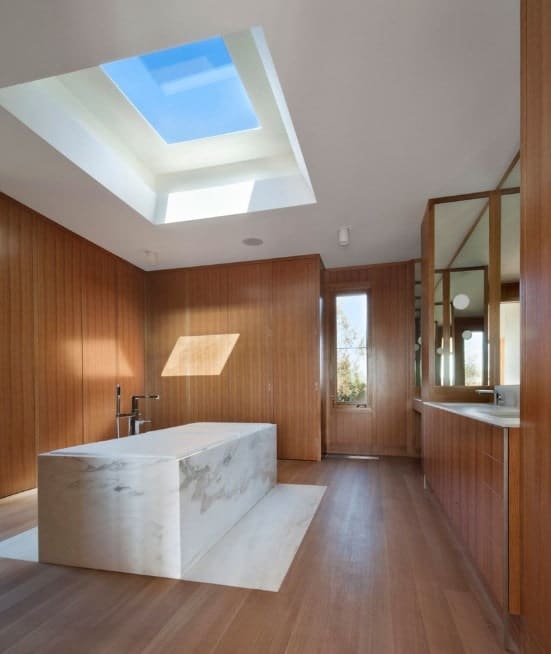 大型主浴室，天窗下有一个迷人的独立浴缸。房间还提供与墙壁相匹配的硬木地板。