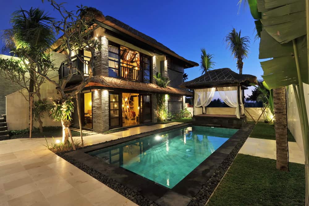 一个令人惊叹的泳池边的家，一个漂亮的长方形游泳池，尽头有一个小屋。