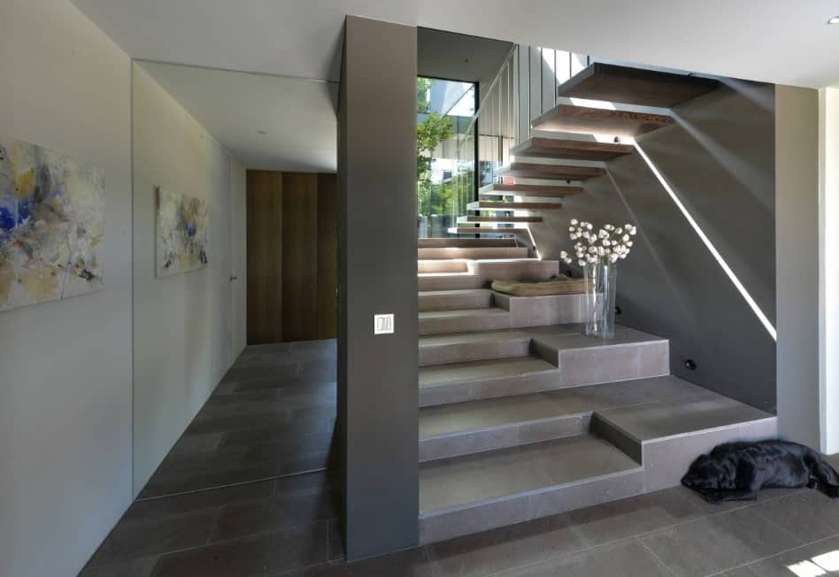 现代带回家一个非常时髦的楼梯。大玻璃窗户让阳光通过,光明的楼梯。