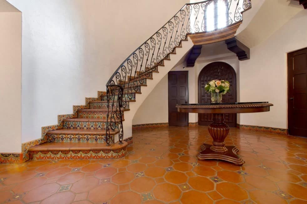 门厅里铺着非常吸引人的瓷砖地板和一张圆形餐桌。楼梯上有漂亮的栏杆。
