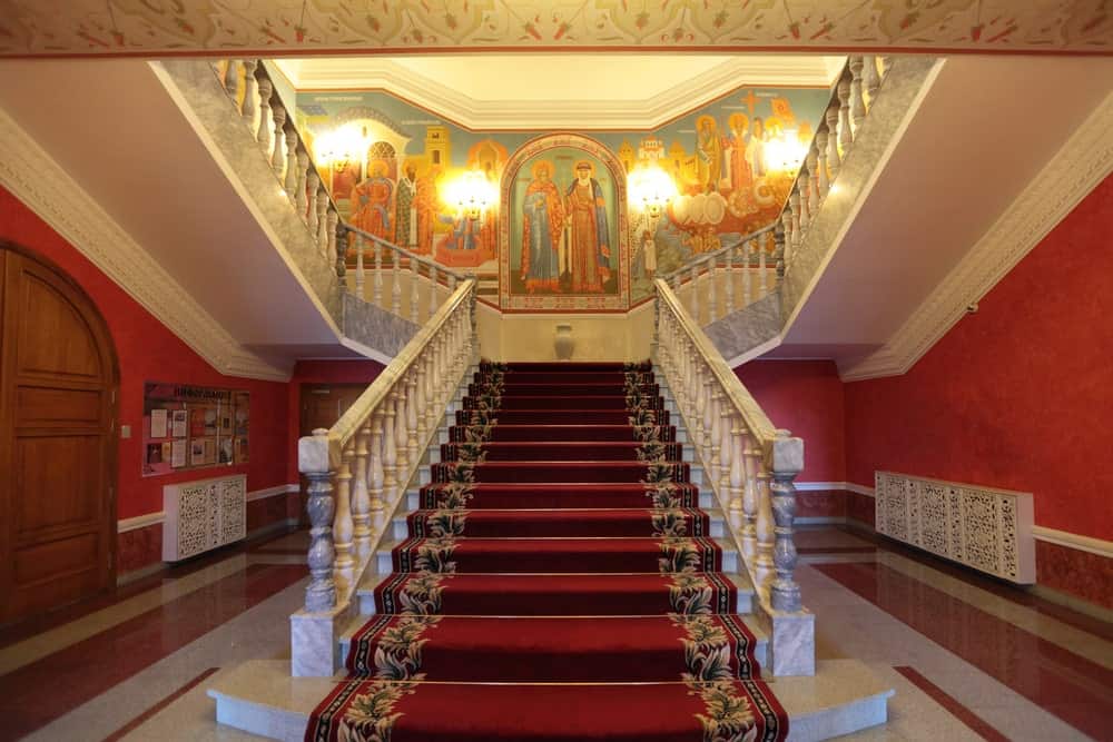 一个优雅的红色楼梯与花卉边界，与墙壁互补包裹这个大理石楼梯。