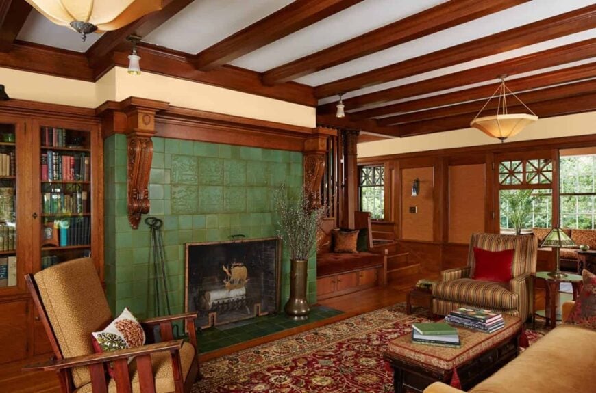 这间木质客厅里，一座绿色的砖砌壁炉格外显眼。它的特点是裸露的木梁天花板，挂着吊灯，还有一个木制沙发，放在红色的复古地毯上。
