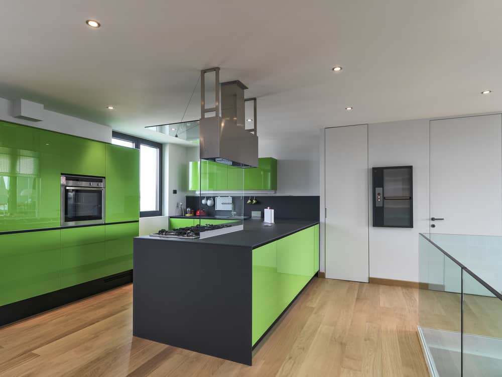 这是一个超现代的厨房，霓虹灯绿色很好用。这绝对是一个独特的设计和配色方案，但光滑的现代橱柜看起来很好，像这样的亮绿色。