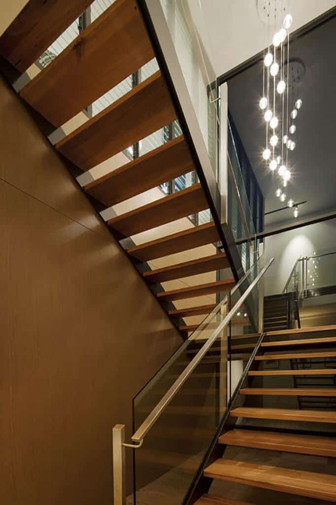 木制半旋转楼梯与玻璃栏杆照明与气泡水晶球吊灯。