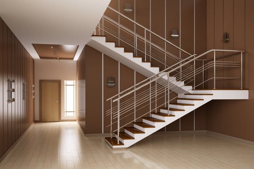 一个双色半转弯楼梯，不锈钢栏杆和木制踏板，沿着走廊的棕色墙壁。