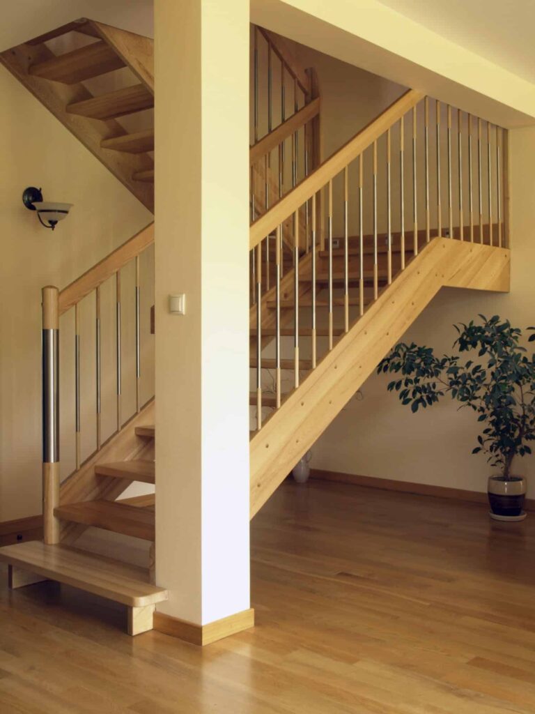 轻木楼梯与开放式立管和不锈钢主轴的硬木地板相辅相成。它由壁灯照明，并设计了盆栽植物，为空间带来了活力。