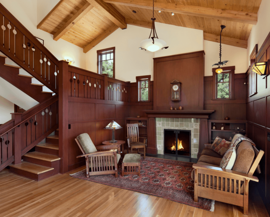 小工匠客厅上方的木质拱形天花板上挂着迷人的吊坠。房子里有一个燃木壁炉，一张老式地毯上放着一套木制沙发。
