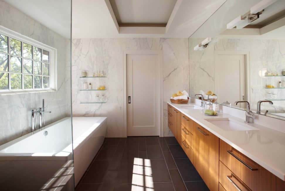 主浴室设有白色大理石墙壁和一个大型白色独立浴缸，以及一个步入式淋浴房和一个双水槽。