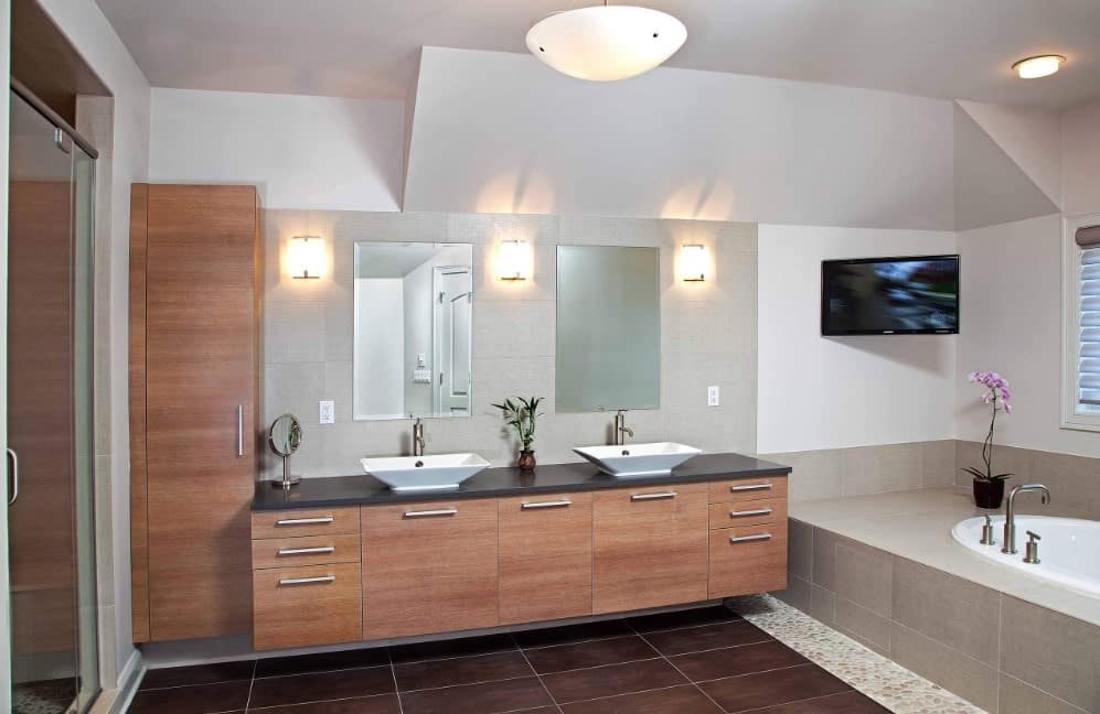 大型主浴室设有一对由壁灯照明的船水槽和一个步入式淋浴房以及一个浴缸。