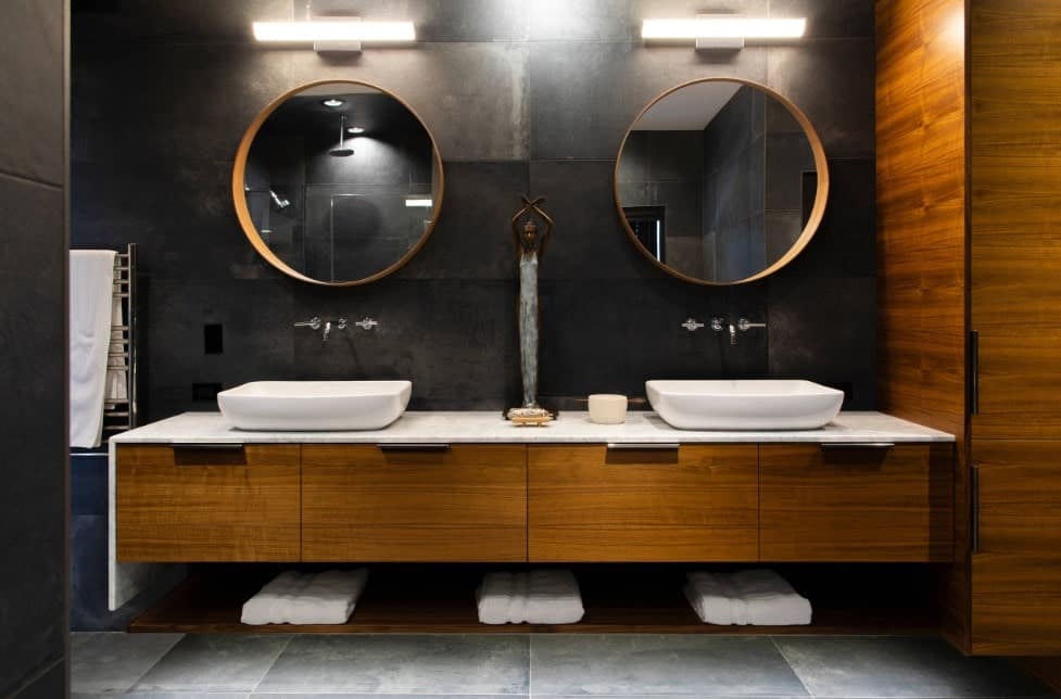 主浴室有优雅的黑色墙壁和灰色瓷砖地板。它的特点是一个漂浮的梳妆台和两个由壁灯照明的容器水槽。
