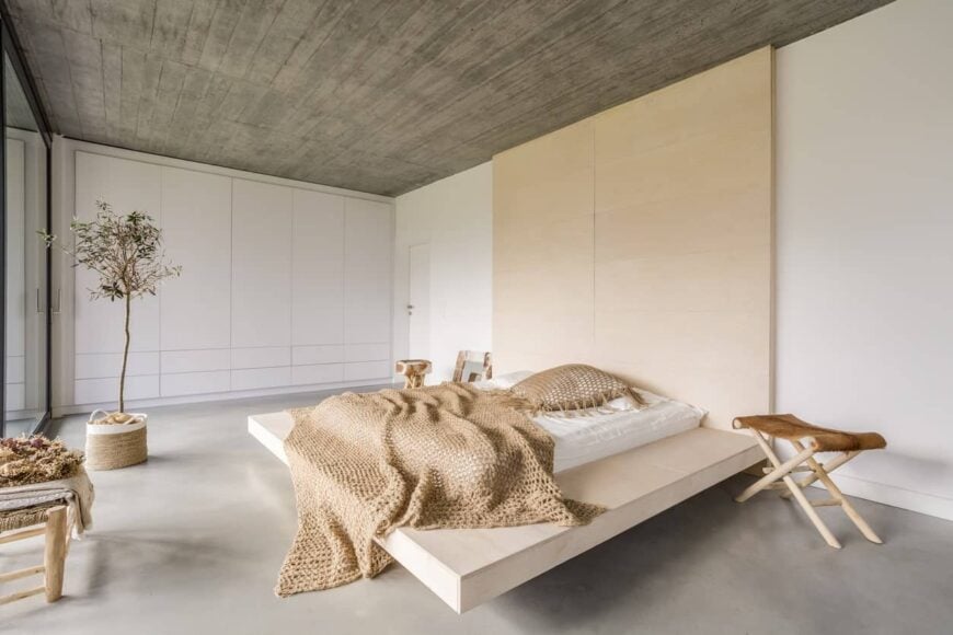 大的主卧室有白色的墙壁，地毯地板和灰色的天花板，看起来非常帅气。床也绝对是迷人的。