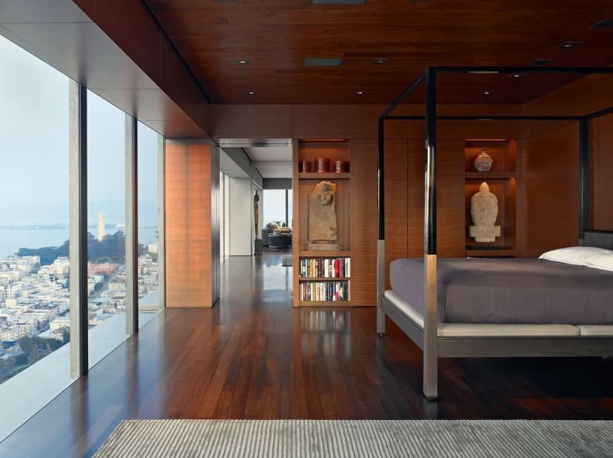 主卧室设有优雅的木墙，天花板和地板，以及玻璃窗，可以俯瞰令人惊叹的室外景色。
