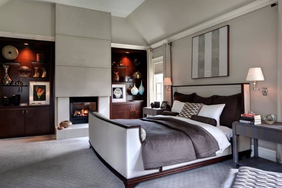 主卧室设有优雅的搁架，位于壁炉的两侧。房间里有一张铺着地毯的舒适的床。