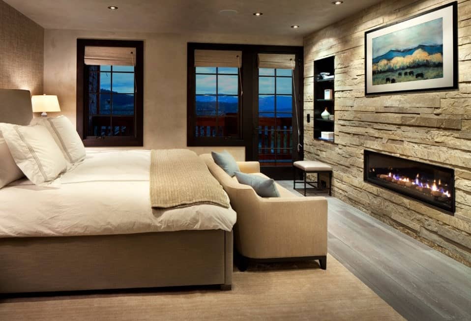 主卧室设有一面带嵌壁式书架和壁炉的漂亮墙壁。房间以硬木地板为特色，上面铺着优雅的地毯，上面有大床和舒适的沙发。