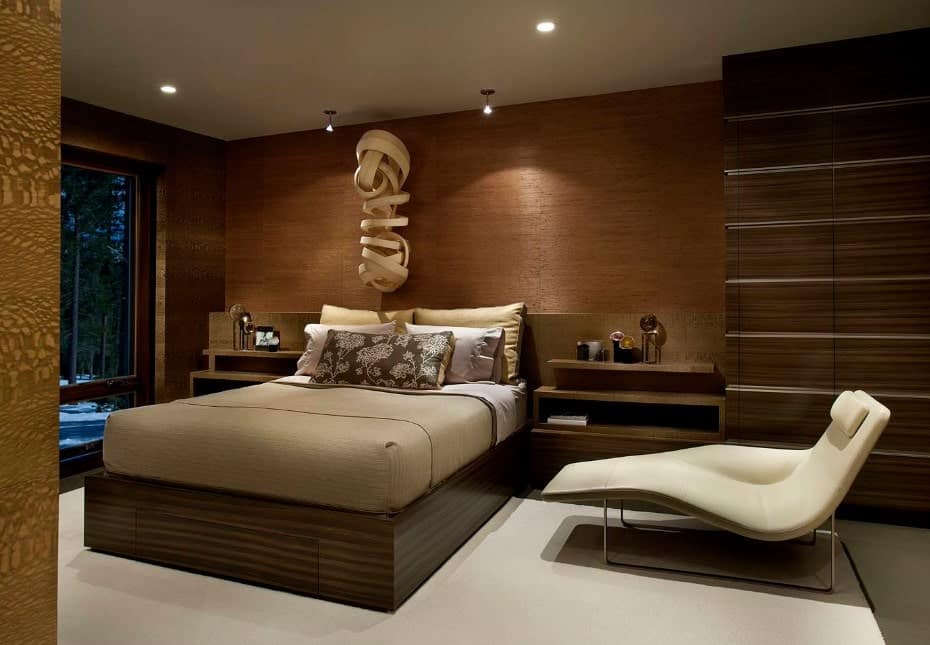 现代的主卧室有一个时尚的木墙和一个时髦的床，两个带内置架子的边桌。墙壁装饰也绝对迷人。