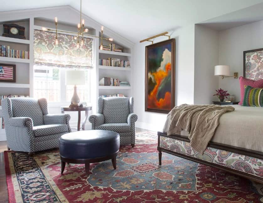主卧室设有一个漂亮的休息区，有两把迷人的椅子和一个搁脚凳，放在覆盖硬木地板的大地毯上。这个房间由优雅的天花板灯照亮。