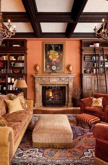 传统橙色主题的客厅，带格子天花板，维多利亚风格的吊灯，传统地毯，软垫中心桌，古董家具，和舒适的沙发。