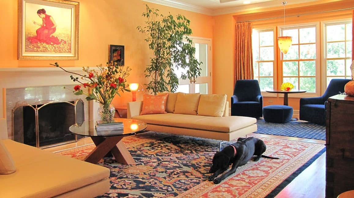 在这个当代客厅里，东西方的华丽结合。错综复杂的编织古董地毯，蓝色和橙色的皮革沙发，大理石壁炉与金色的口音，水晶花瓶，灯，和巨大的落地窗补充房间。