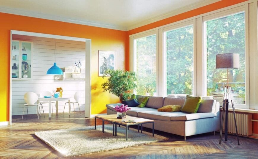 简单而时尚的橙色客厅，硬木地板，大窗户，落地灯，灰色沙发，蓬松的米黄色地毯。