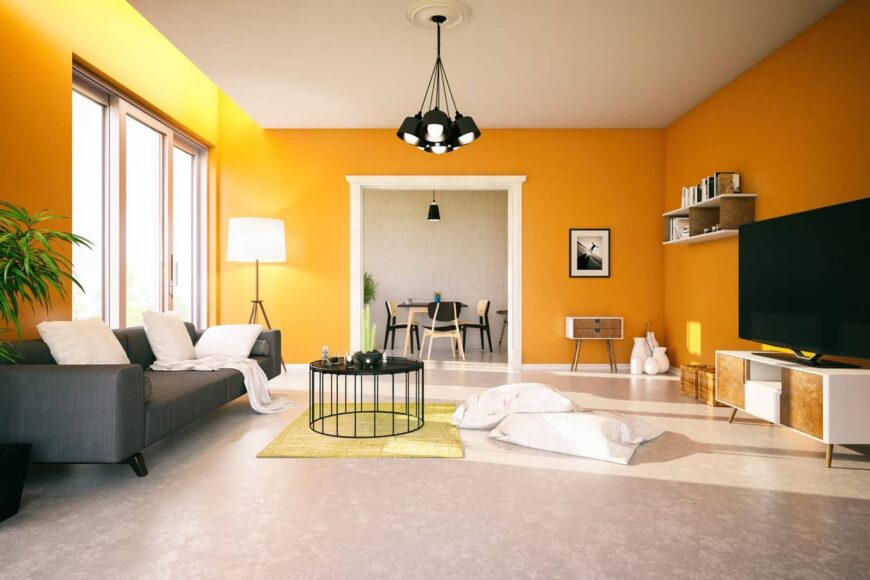 宽敞的客厅，橙色的墙壁，浮动的架子，灰色的沙发，圆形的金属中心桌子，黑色的吊灯。