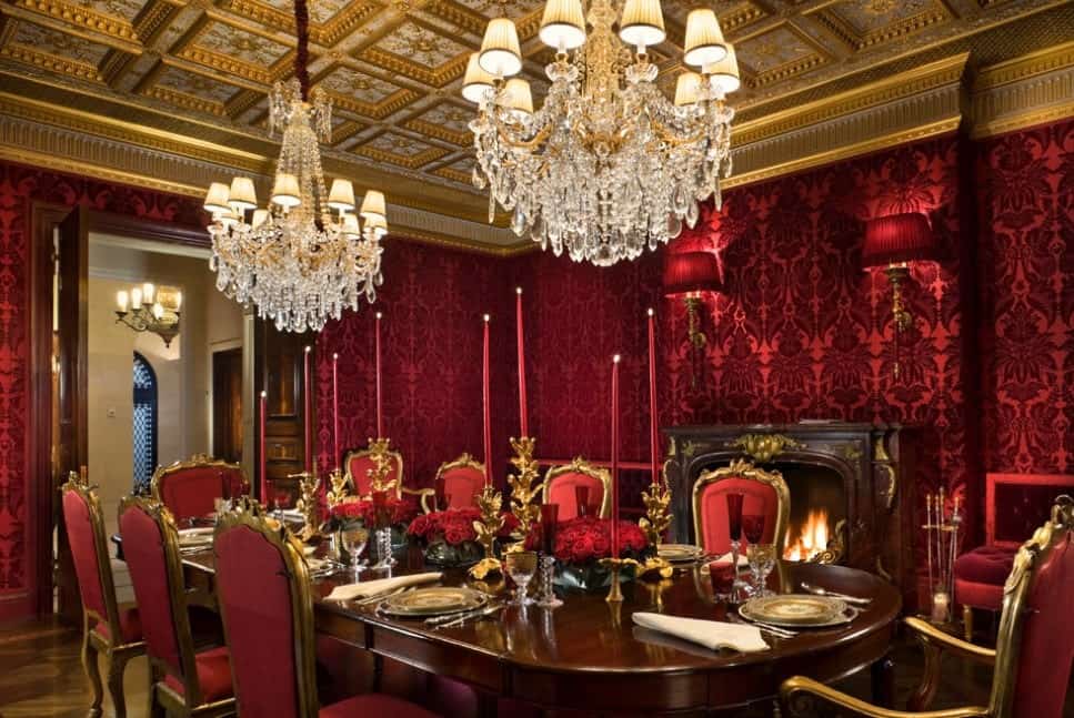 红色和金色是这个正式的传统餐厅的主要色调。镀金的古色古香的壁炉前是古董八个座位的红色软垫椅子和椭圆形的长桌，镀金的烛台，水晶玻璃杯，珍贵的瓷器，银器闪闪发光，像两个传统的水晶吊灯挂在一个金色的格子天花板上，而红色的烛台与墙纸的墙壁相匹配。