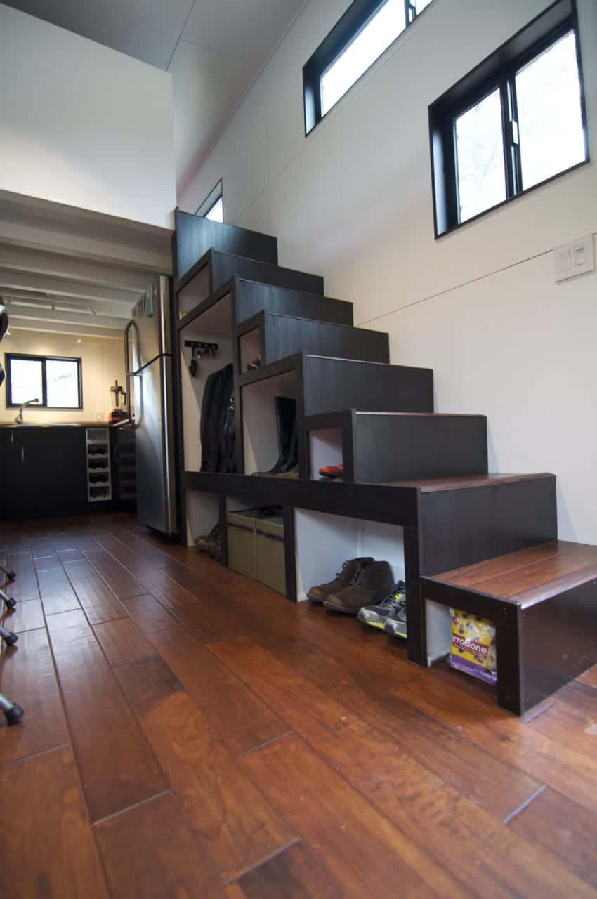 这个黑色和棕色的楼梯提供了一个伟大的存储解决方案。它有架子放你的衣服、鞋子和其他东西。没有衣柜吗?没问题!