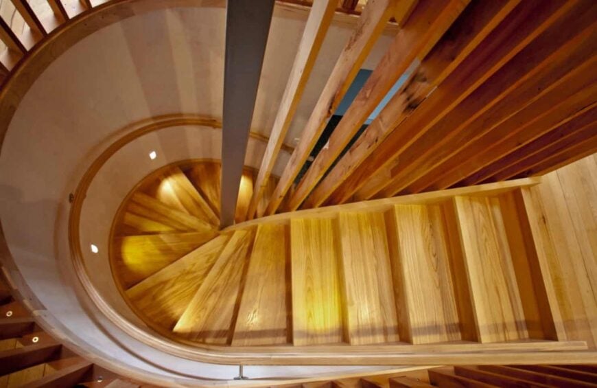 一个优雅的木楼梯的俯视图与弯曲的内桁和回收的里木栏杆。