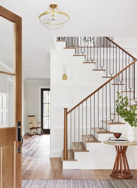 华丽的楼梯，有锻铁主轴和黄铜扶手。它的木地板与白色的护墙板相辅相成。