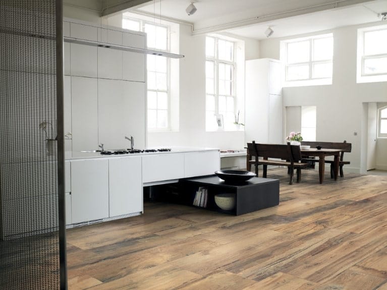 宽敞的厨房，白色橱柜和玻璃窗带来充足的自然光线。它包括一张深色的木制餐桌，与硬木地板上配套的长椅搭配在一起。