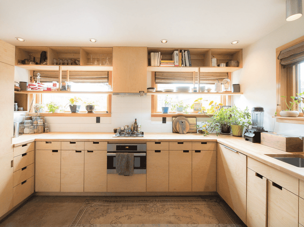 通风的厨房提供带开放式搁架的浅色木质染色橱柜。它以盆栽植物为重点，为房间增添了清新的氛围。