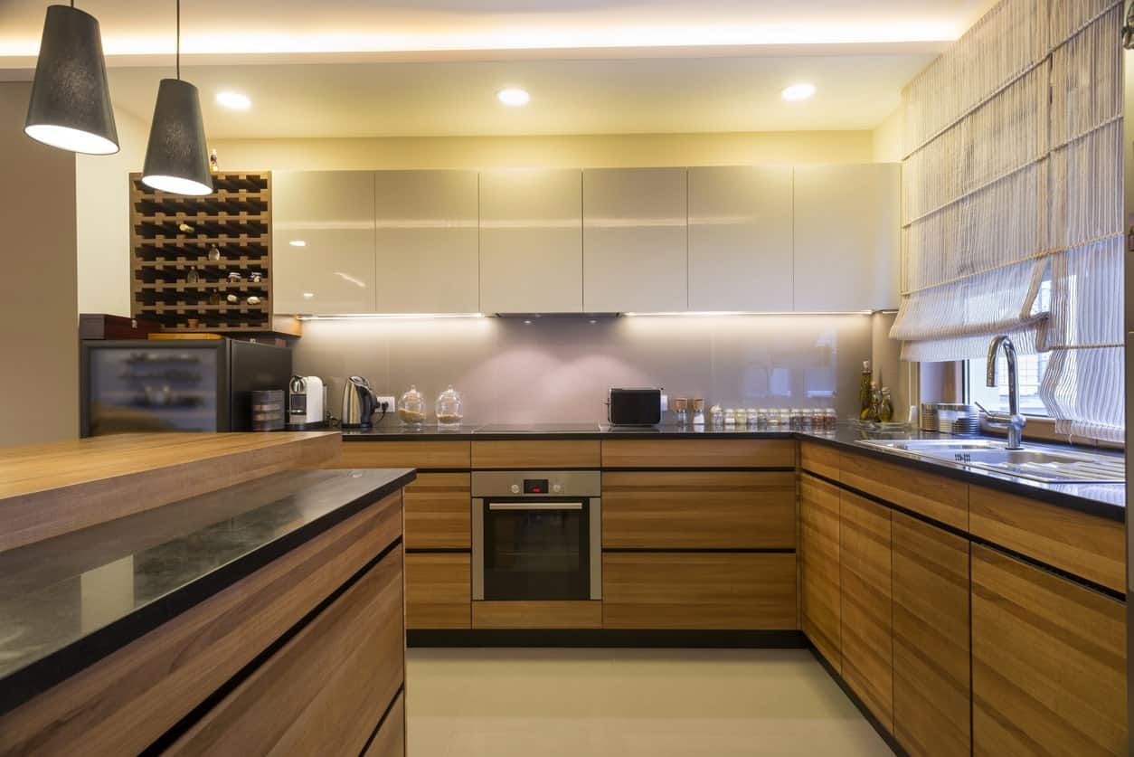 这间厨房提供光滑的白色上层橱柜，与内置的木质酒架和与下层橱柜相匹配的早餐岛形成了美丽的对比。
