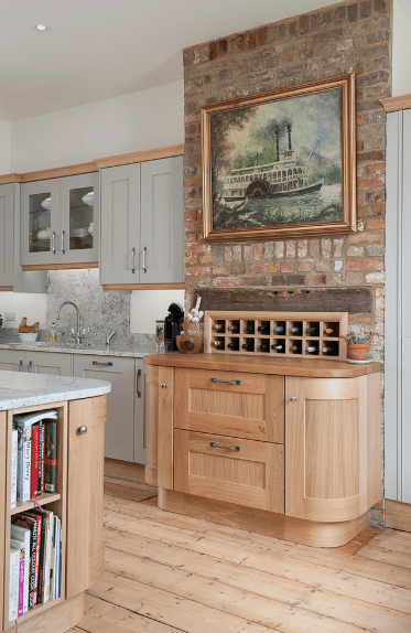 厨房有一面砖砌的强调墙，设计了一个有框架的艺术作品，水平的酒柜安装在木质台面和橱柜上。