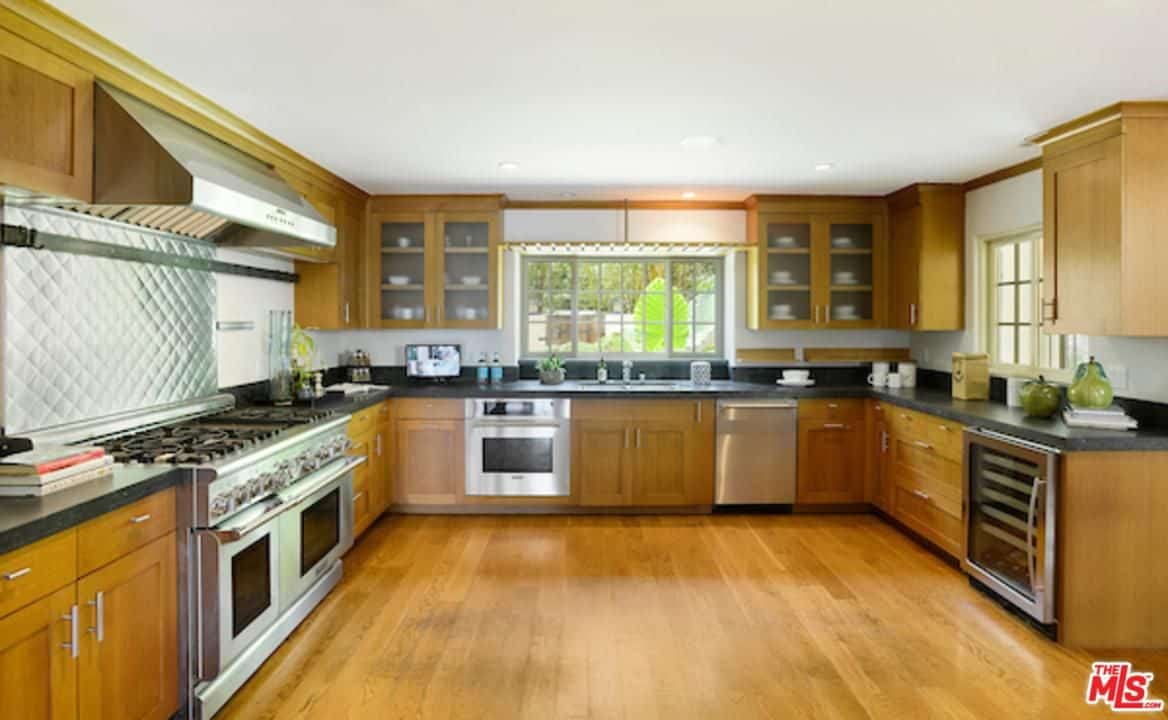 宽敞的厨房拥有木制橱柜，与硬木地板相辅相成。它有不锈钢电器和内置酒柜。