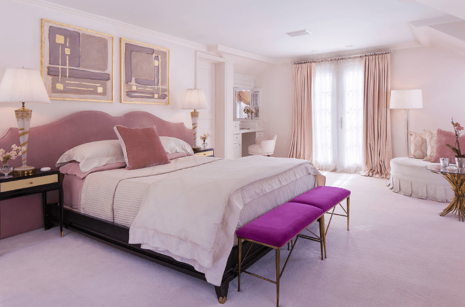 华丽的主卧室设计有一对华丽的墙壁艺术作品安装在软垫床上。房间里有一张靠落地灯照亮的拥抱椅，正对着白色的梳妆台区。
