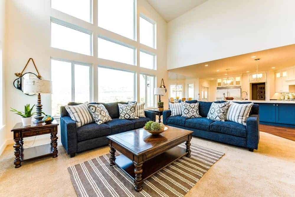 明亮的起居区域以深色木桌、条纹地毯和深蓝色部分为特色，为房间增添了一抹亮色。